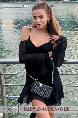 Cute young petite blonde girl in a sexy black dress